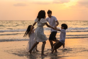 Young happy family enjoy vacation on beach in the evening.